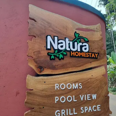 a sign on the side of a building at Natura Homestay in Padinjarathara