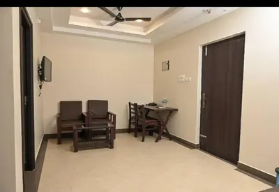 a room with a table and chairs and a door at Guruvayoor Suits Pankaj Suits in Trichūr
