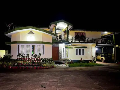 a large white house at night with at Coorgglade in Kakkabe