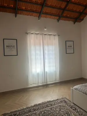 a bedroom with a bed and a large window at Airy haven in Kushālnagar