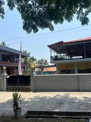 a building with a white fence and a flag at Airy haven in Kushālnagar