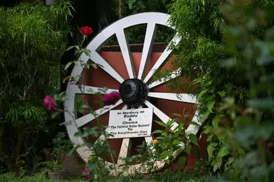 a woodenwheel in a garden with a sign on it at The School Estate in 100 Acres in Siddapur