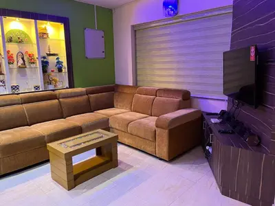a living room with a couch and a tv at Sunset View Inn in Irinjālakuda