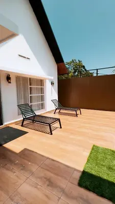 two benches sitting on a wooden patio at Fog Land Pool Villa by BMT in Vythiri