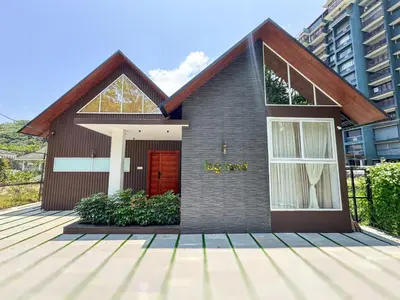 a house with a red door on a wooden deck at Fog Land Pool Villa by BMT in Vythiri
