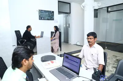 a group of people sitting around a table with a laptop at Erica Hotel International in Perintalmanna