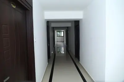 a corridor of a room with two doors at Erica Hotel International in Perintalmanna