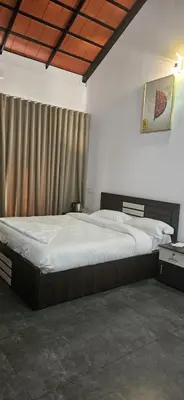a bedroom with a large bed with white sheets at Royal Heaven in Ambalavayal