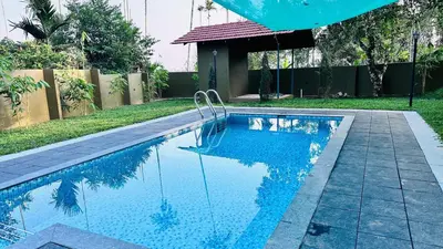 a swimming pool with blue water in a yard at Royal Heaven in Ambalavayal