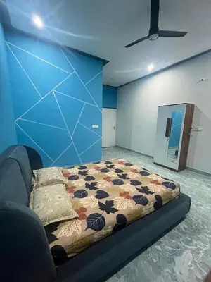 a bed in a room with a blue wall at Chamundi Temple-Hill View in Mysore