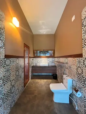 a bathroom with a toilet and a sink at Tangerine Tales Boutique Resort By LexStays in Wayanad