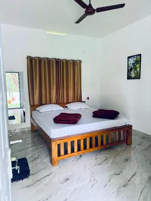 a bed in a room with a ceiling fan at Anya Retreats Nature Homestay in Kushālnagar