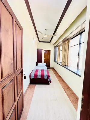 a bedroom with a bed and a door at Hotel Alsaj in Alwaye