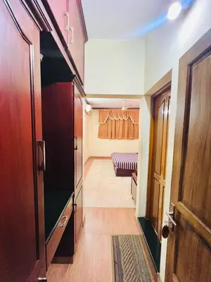 a hallway with a room with a couch and a door at Hotel Alsaj in Alwaye