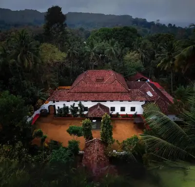 an aerial view of a house with a red roof at SaffronStays Amaya - 5BR 300-year-old Kerala-style heritage villa with spa near Kannur Airport in Irikkūr