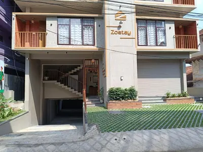 a house with a staircase in front of it at Zostay Urban Retreat Deluxe Rooms & Premium Dorms in Manjeri