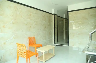 two orange chairs and a table in a bathroom at S M Residency in Tiruppūr