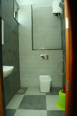 a bathroom with a white toilet and a sink at S M Residency in Tiruppūr