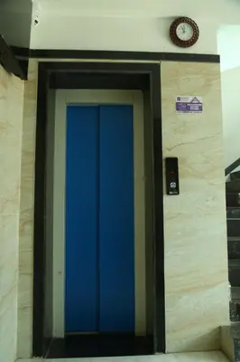 a blue door in a building with a clock on the wall at S M Residency in Tiruppūr