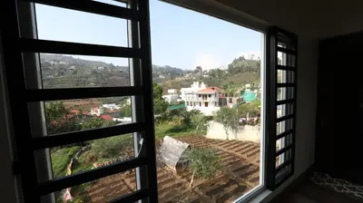 an open window with a view of a city at Mira Homestay in Kodaikānāl