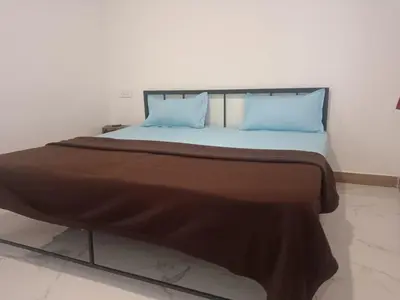 a large bed with two blue pillows on it at Riverside inn in Wayanad