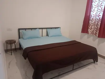 a bed with blue pillows in a room at Riverside inn in Wayanad