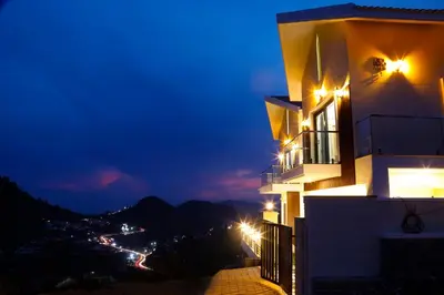 a building with a view of a city at night at May Flower Cottage in Ooty