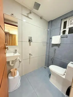 a bathroom with a toilet and a sink and a shower at Stay Bridge Residency in Kozhikode