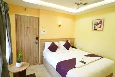 a bedroom with a bed and a wooden door at M M Hotel Royal Respite in Coimbatore