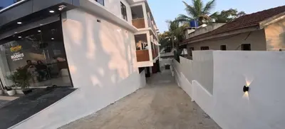 a street view of a white building with a storefront at Smile Residency in Sultan Bathery