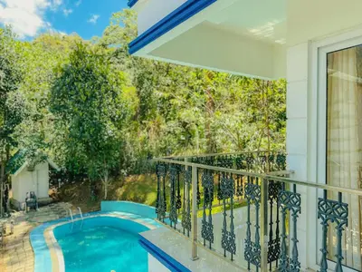 a balcony with a swimming pool and a window at The Heights Munnar in Munnar
