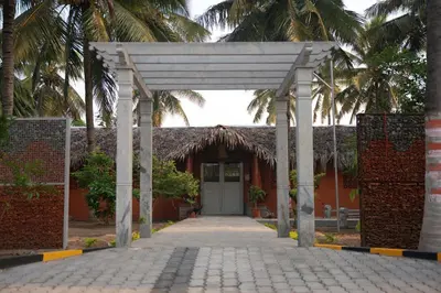 a hallway leading to a building with a white door at Metro Club Resort in Kāmānayakkanpālaiyam