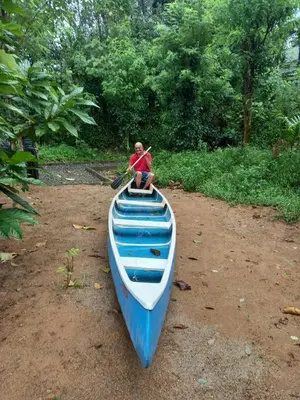 a person sitting on top of a blue and white canoe at Rainy Woods Inn in Neriyamangalam
