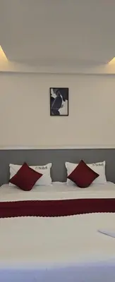 a bed with red and white pillows on it at Redbell Suites Civil in Kozhikode