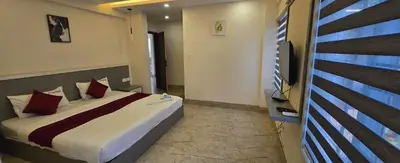 a bedroom with a bed and a flat screen tv at Redbell Suites Civil in Kozhikode