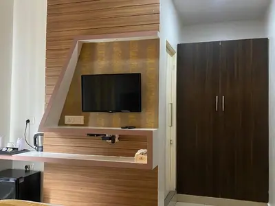 a room with a tv on a wall at Pumpkin Tower in Malappuram