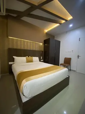 a bedroom with a large bed and a chair at Pumpkin Tower in Malappuram