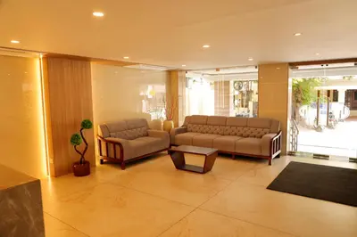 a living room with two couches and a table at Hotel Le Palace in Coimbatore