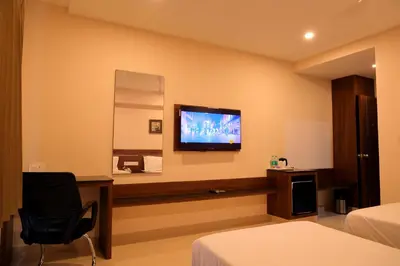 a hotel room with a flat screen tv on the wall at Hotel Le Palace in Coimbatore