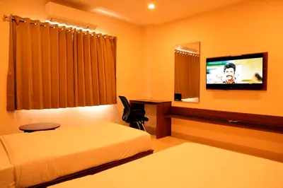 a hotel room with a bed and a flat screen tv at Hotel Le Palace in Coimbatore