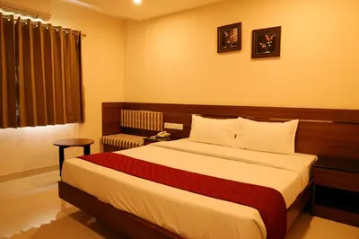 a hotel room with a bed and a window at Hotel Le Palace in Coimbatore