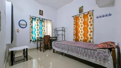 a bedroom with a bed and a table and curtains at Spacious 2-storey home-4 bedroom in Kunnamkulam