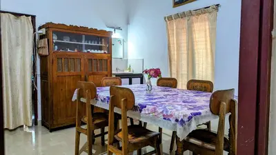 a dining room with a table and chairs and a kitchen at Spacious 2-storey home-4 bedroom in Kunnamkulam