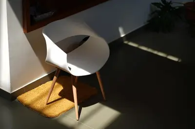 a white chair sitting on a rug in a room at Verdant Courtyard, 3BHK, Near IIM, NITC in Kozhikode
