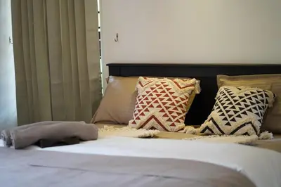 a bedroom with a bed with pillows on it at Verdant Courtyard, 3BHK, Near IIM, NITC in Kozhikode