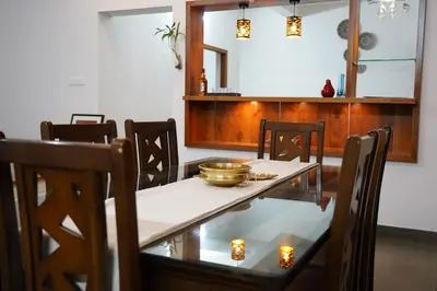 a dining room with a table with a bowl on it at Verdant Courtyard, 3BHK, Near IIM, NITC in Kozhikode