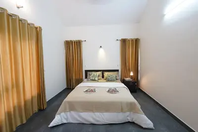 a bedroom with two beds and curtains in it at Verdant Courtyard, 3BHK, Near IIM, NITC in Kozhikode