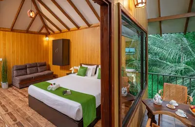 a bedroom with a bed and a couch in a room at De Spicewoods, AC Cabin, Pool, Couple only in Kalpetta