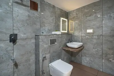 a bathroom with a toilet and a sink at De Spicewoods, AC Cabin, Pool, Couple only in Kalpetta