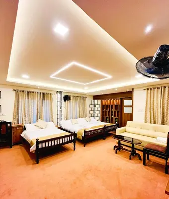 a large room with three beds and a couch at JoeVilla Homestay Near Kottiyoor in Kelakam